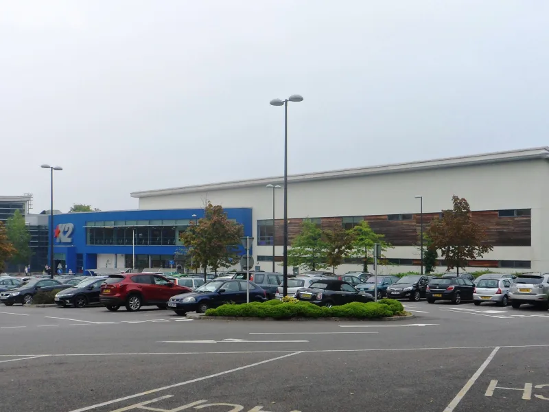 The blue and white frontage of K2 Crawley leisure centre seen across its car park