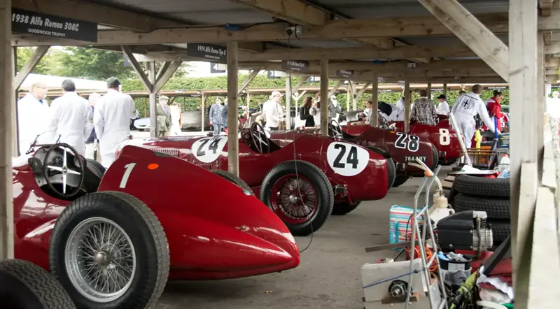 Cars lined up at the Goodwood Festival of Speed hillclimb on a bright summer day